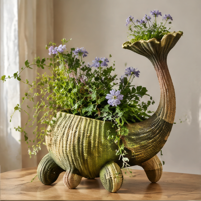 Green and brown handwoven sculptural vase with a curved flared neck, four-legged base and purple flowers