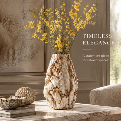 Ivory shell vase styled with yellow flowers beside books and decorative objects
